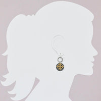 Earring displayed on a white silhouette against a light gray background