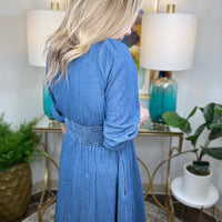 Woman wearing a blue denim dress with zipper accent.