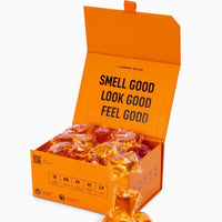 Orange box of laundry detergent packets with text 'Smell Good, Look Good, Feel Good' on a white background.