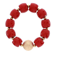 Red beaded bracelet with a gold accent on a white background