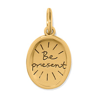 Gold pendant with 'Be Present' engraving on a white background