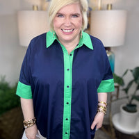 Woman wearing a navy shirt with green color-block accents.