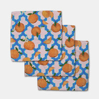 Set of three dishcloths with a pattern of oranges on a geometric blue and light pink background