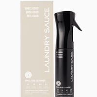 Black spray bottle labeled 'Laundry Sauce' next to a beige box on a white background