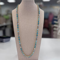 Blue gemstone Necklace on a mannequin bust with a blurred indoor background