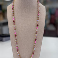 Necklace with pink and multicolored stones on a gray bust