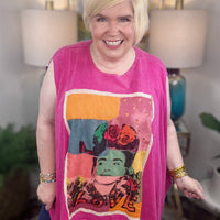 woman wearing a sleeveless bright pink top with a large colorful Frida Kahlo graphic print on the front