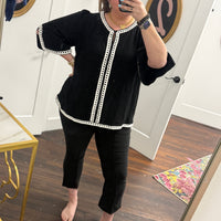 Black pants with a front seam and subtle front slit detail.