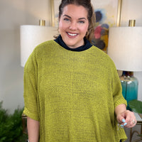 Woman wearing a short sleeved chartreuse sweater.