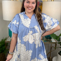 Woman wearing a baby blue floral babydoll dress.