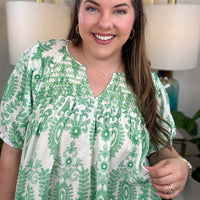 Woman in a green and white print top.