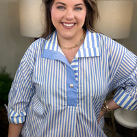 Woman wearing a blue and white striped shirt with pearl button