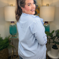 Woman wearing a blue checkered blouse with ruffles