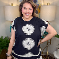 Woman wearing a black top with white starburst design