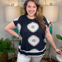 Woman wearing a black top with white starburst design