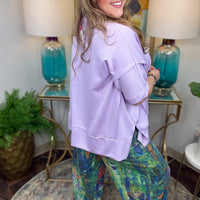 Woman wearing colorful denim pants with vibrant brush stroke pattern.