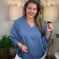 Woman wearing a denim v-neck dolman sleeve blouse