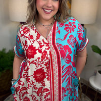 Woman wearing a colorful floral dress in an indoor setting