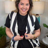 Woman wearing a cream and white striped vest with star appliques
