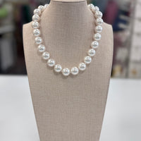 Pearl necklace on a beige display bust with a blurred background