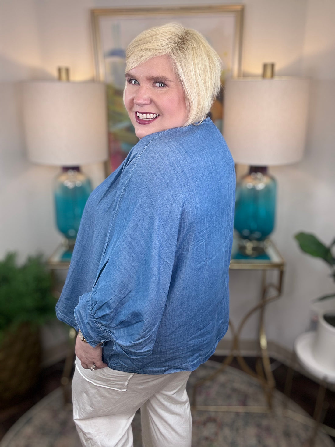 Woman wearing a denim v-neck dolman sleeve blouse