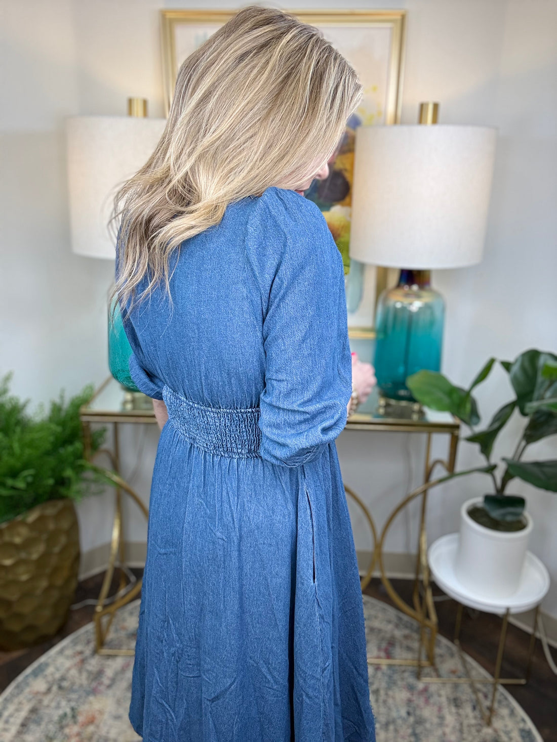 Woman wearing a blue denim dress with zipper accent. 