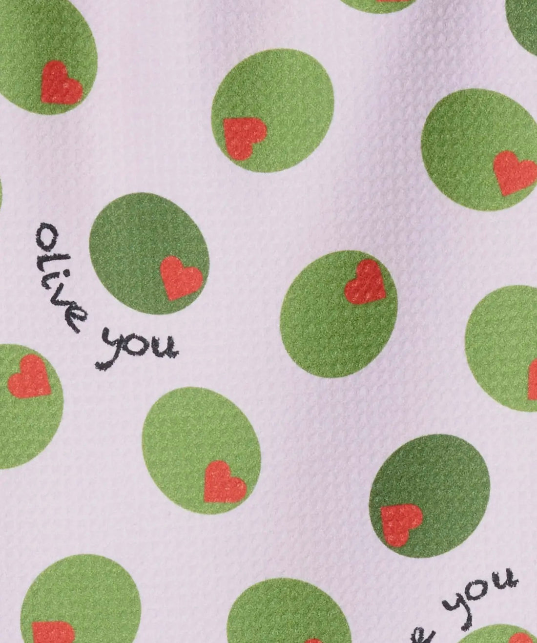 Patterned fabric with green circles and red hearts on a light pink background, featuring the text &