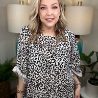 Woman wearing a white leopard print top