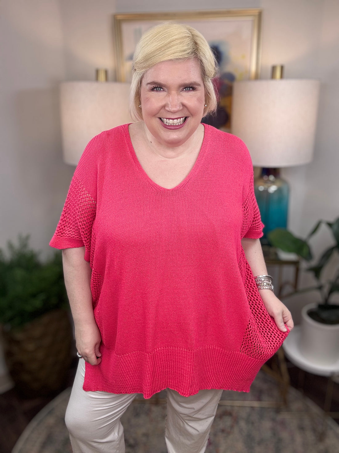 Woman wearing a pink short-sleeved tunic sweater.