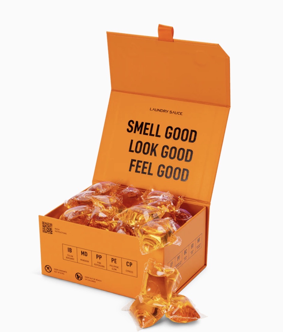 Orange box of laundry detergent packets with text &