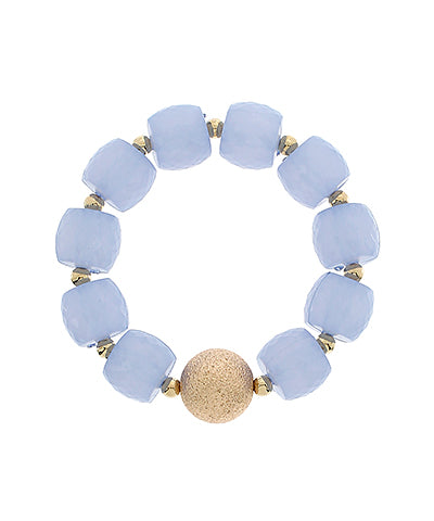 Bracelet with light blue beads and a gold bead on a white background