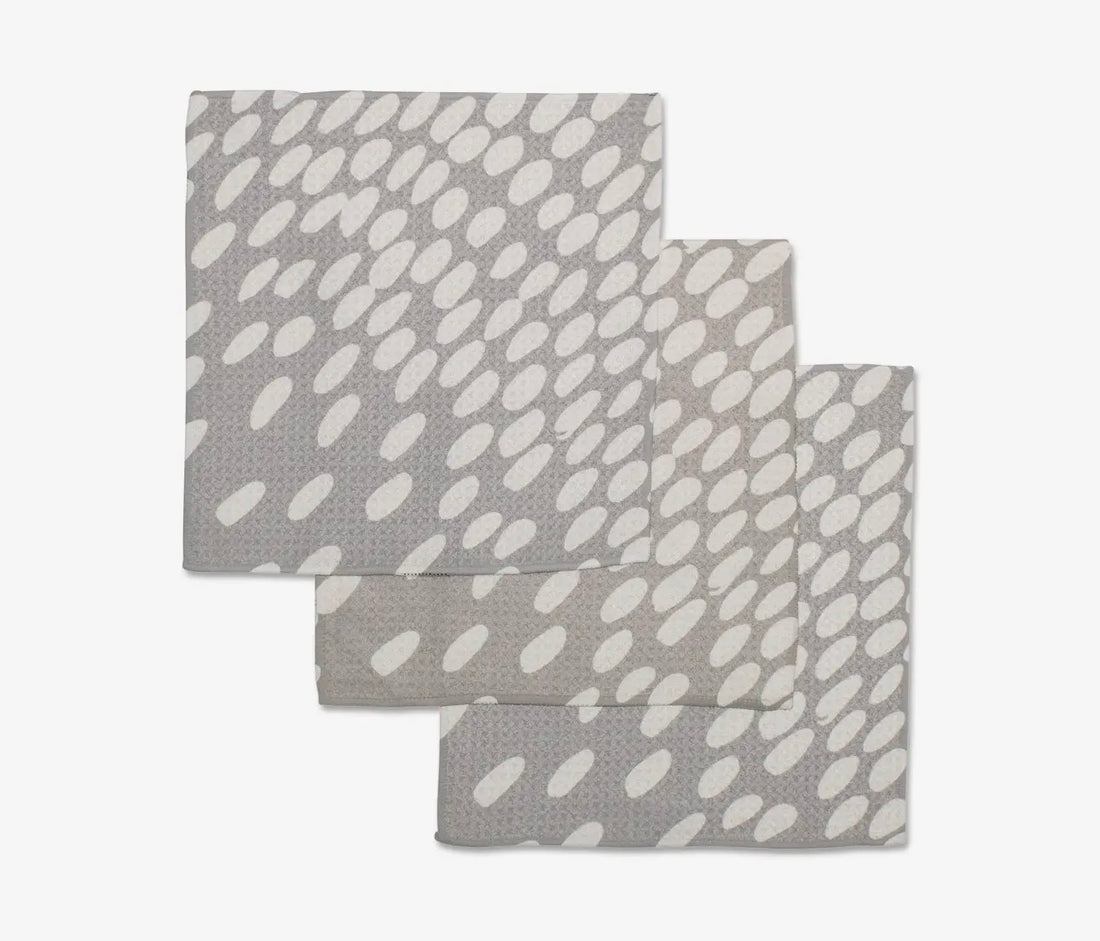 Set of three gray and white patterned towels on a light gray background