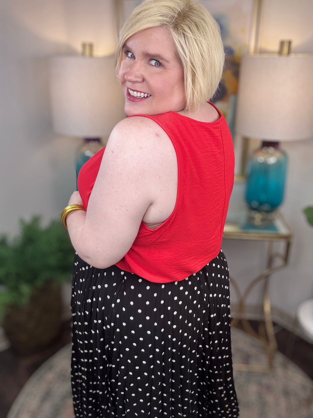 Woman wearing a red top and black polka dot skirt