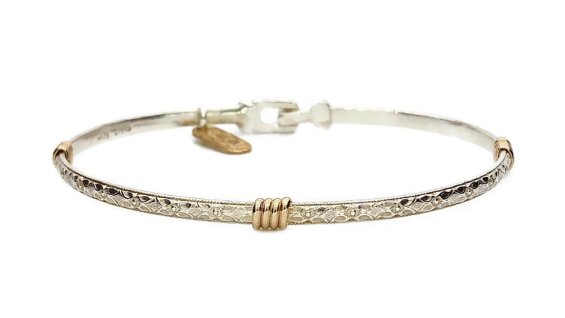 Silver band bracelet with gold wrap detail.
