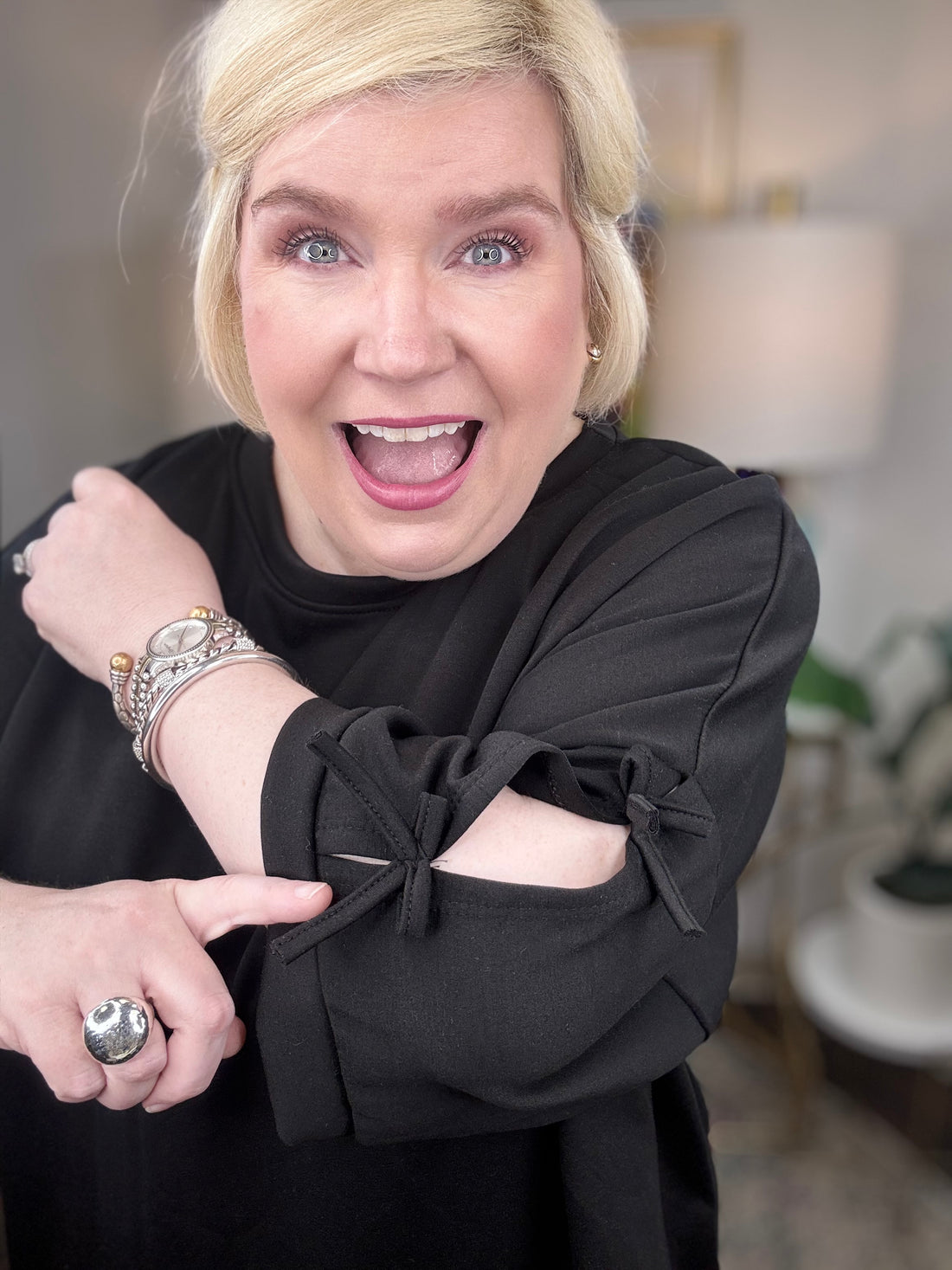 Woman wearing a black matching set with bows tied on the sleeves.