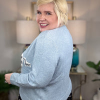 Light blue cardigan with white horse and black spots