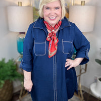 Woman wearing a blue dress with a red scarf in a home setting