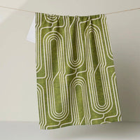 Green tea towel with white geometric pattern on a white background