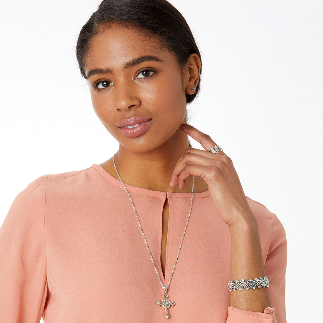 Woman wearing a necklace, ring, and bracelet on a white background