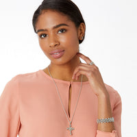 Woman wearing a necklace, ring, and bracelet on a white background