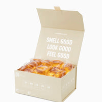 Box of scented candles with 'Smell Good, Look Good, Feel Good' text on a white background