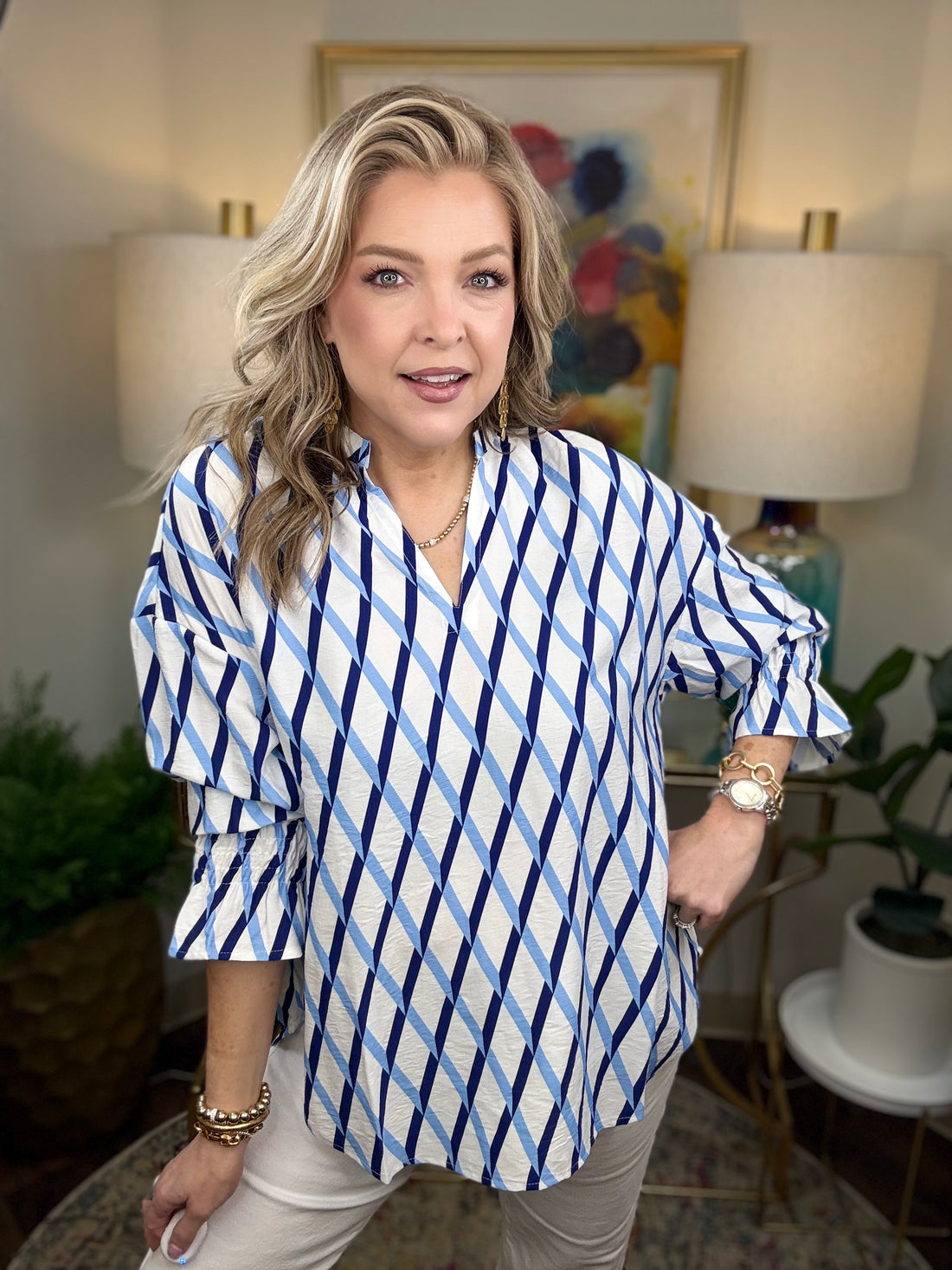 Woman wearing a white blouse with dark and light blue criss cross patterns