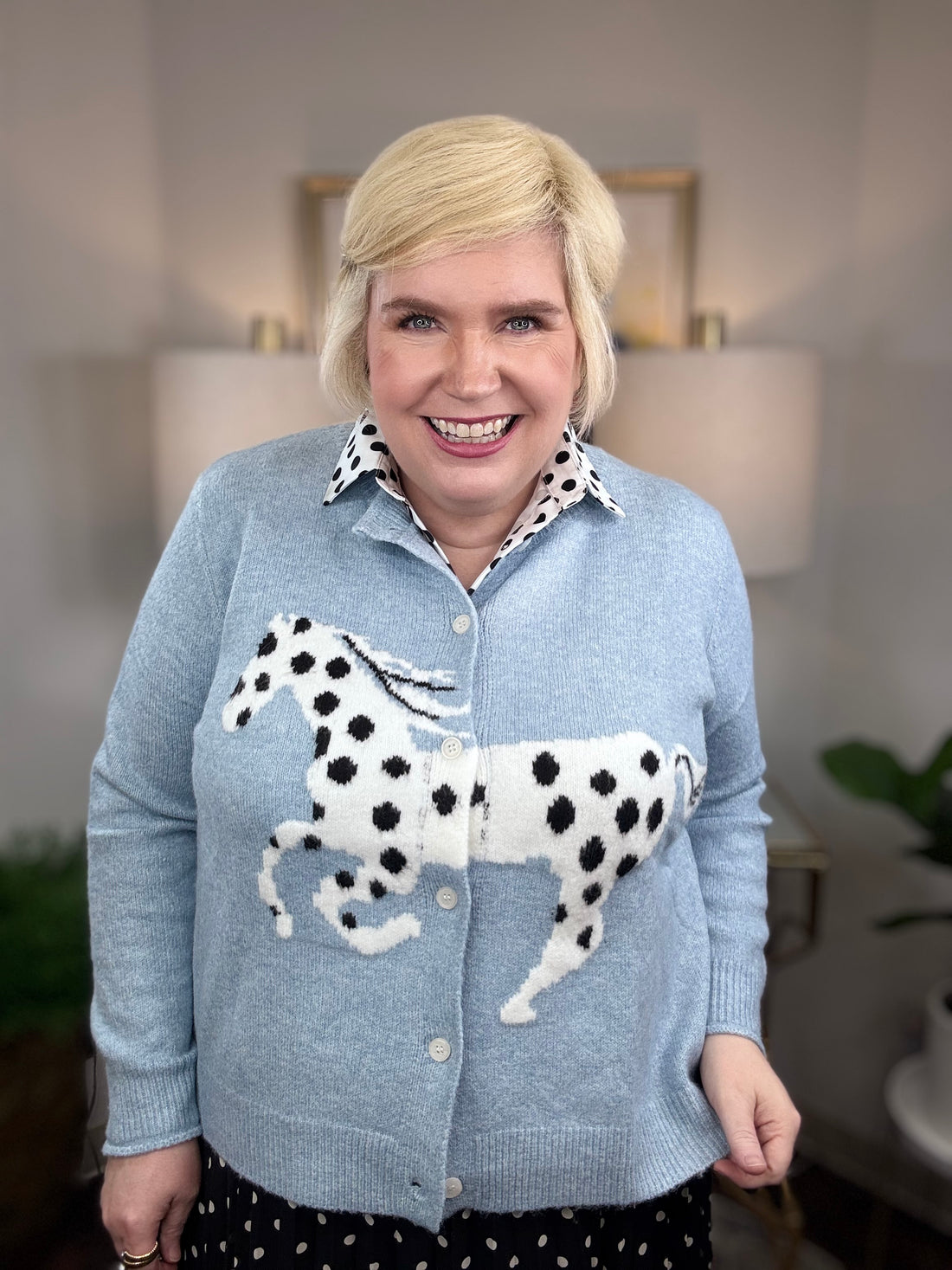 Light blue cardigan with white horse and black spots