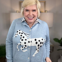 Light blue cardigan with white horse and black spots