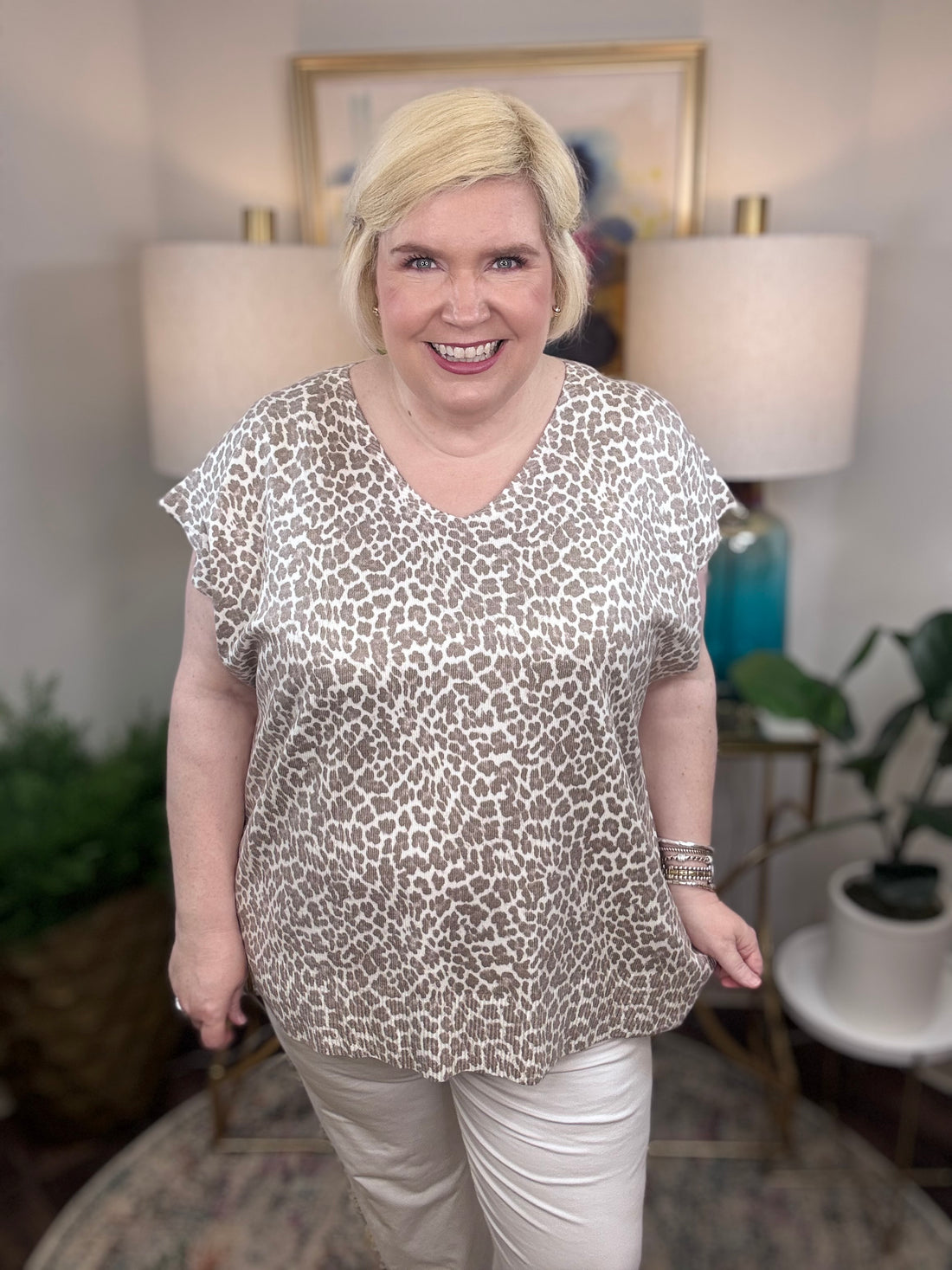 Woman wearing a taupe leopard patterned blouse.