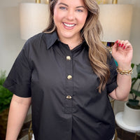 Woman wearing a black blouse with gold buttons