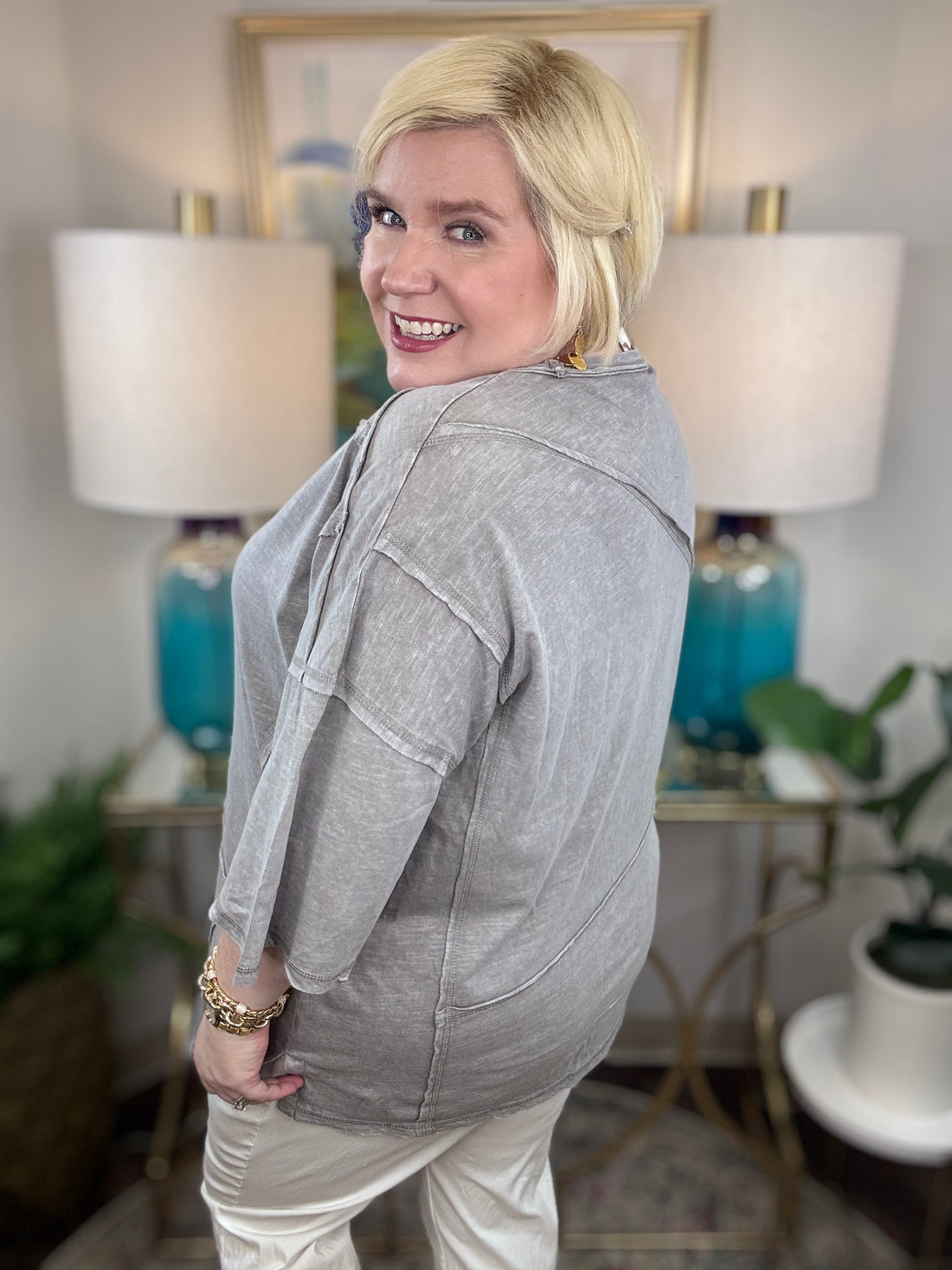 Woman wearing a gray t-shirt blouse. 