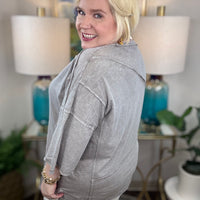 Woman wearing a gray t-shirt blouse. 