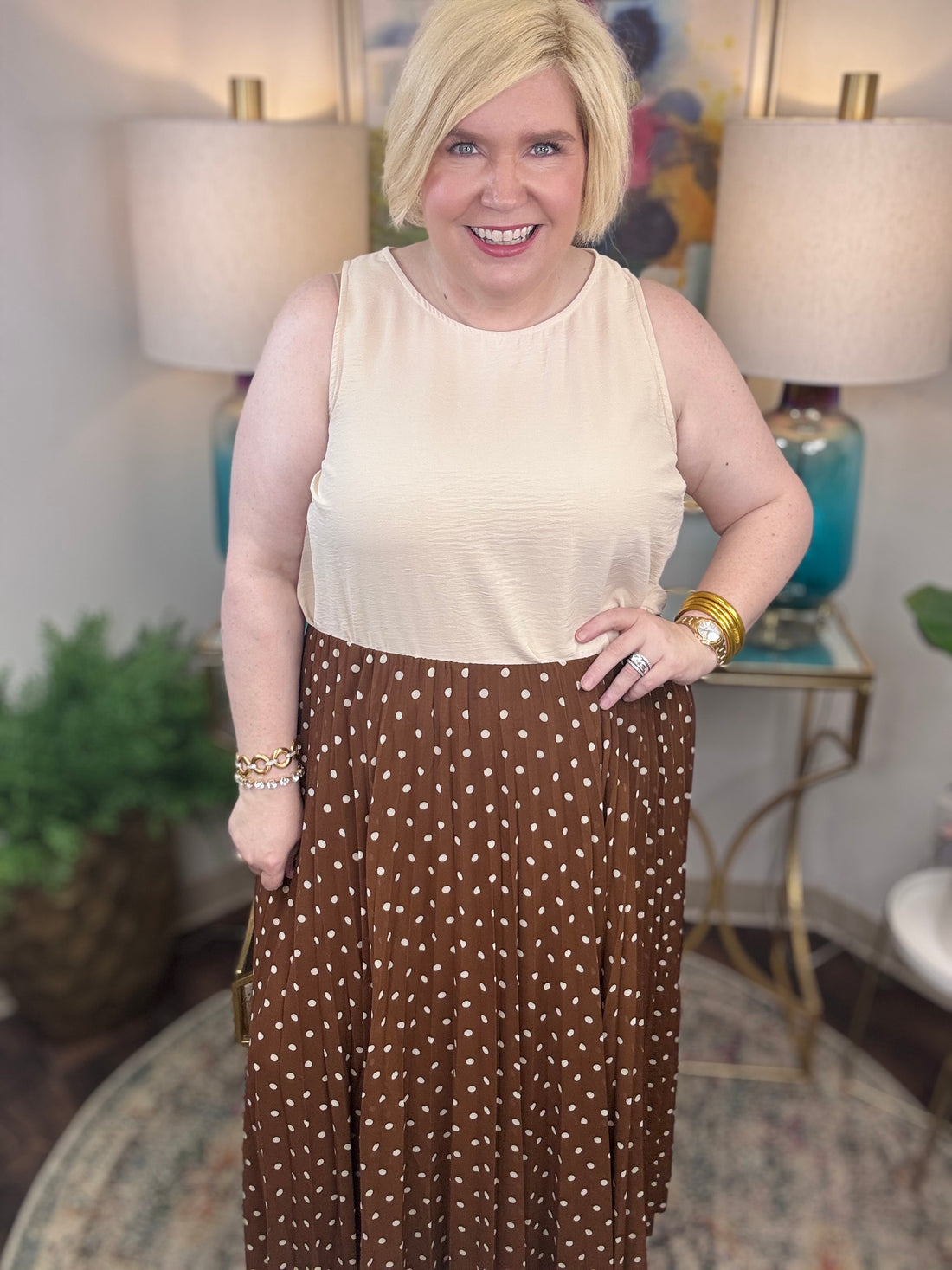 Woman wearing a beige top and brown polka dot skirt