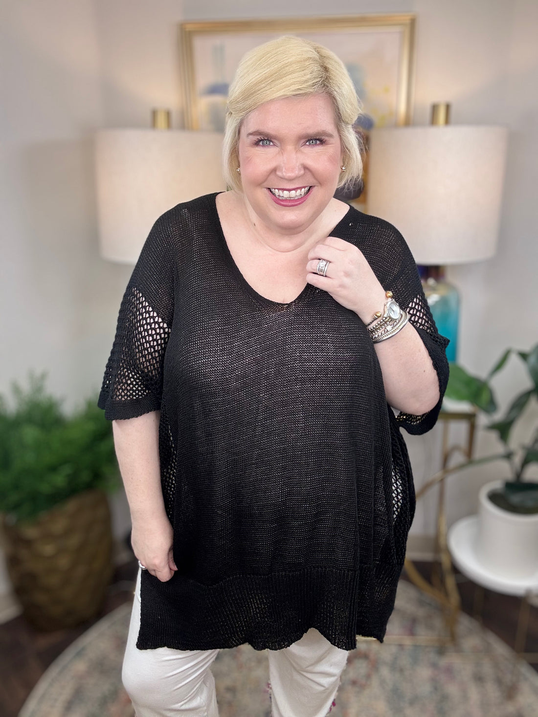 Woman wearing a black short-sleeved tunic sweater.